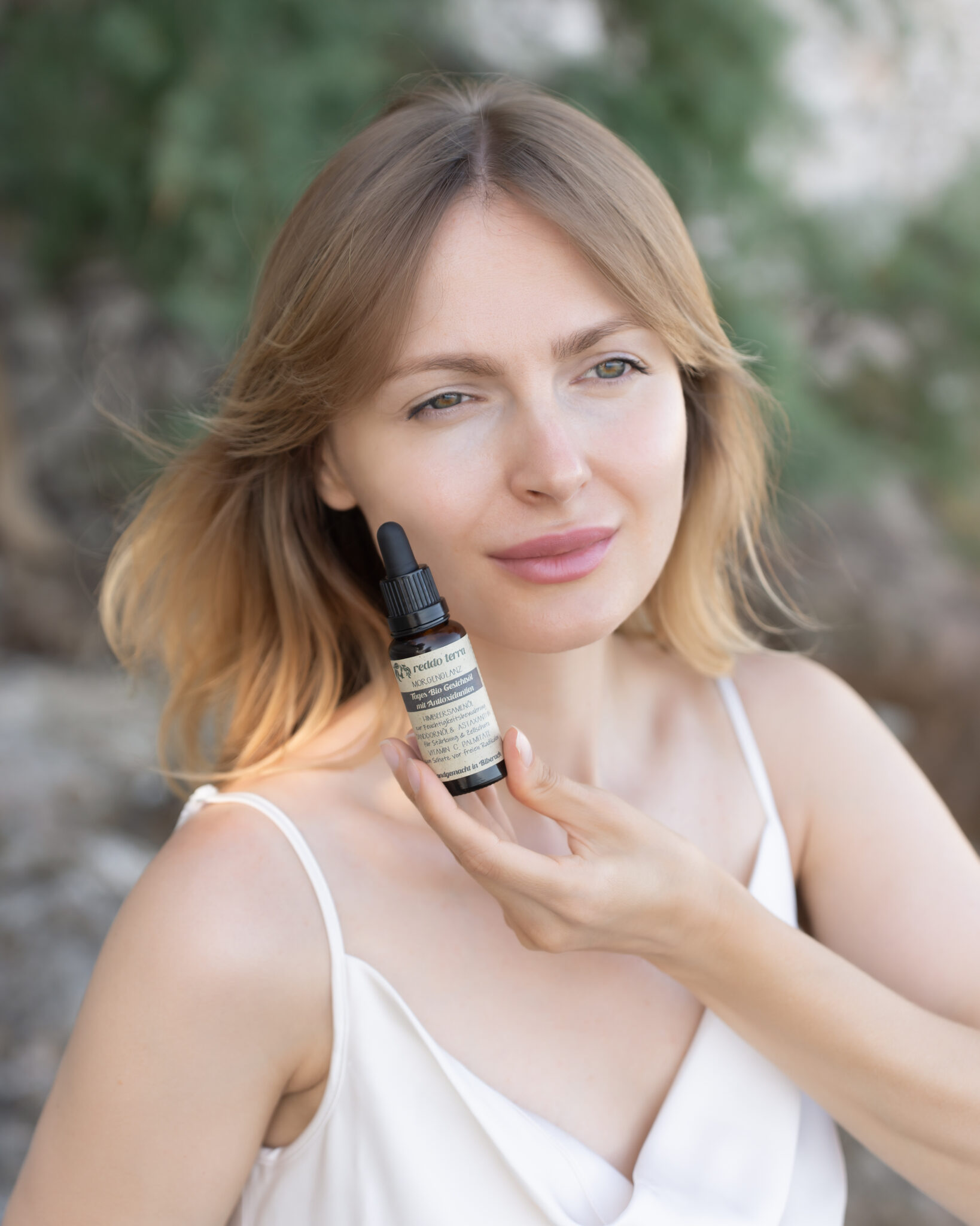 Model am Strand mit Morgenglanz Bio Gesichtsöl von Reddo Terra