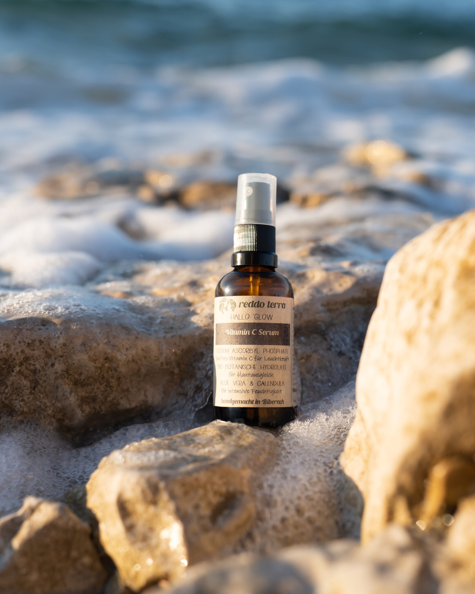 Hallo Glow Vitamin C Serum für unreine Haut auf einem Felsen am Strand